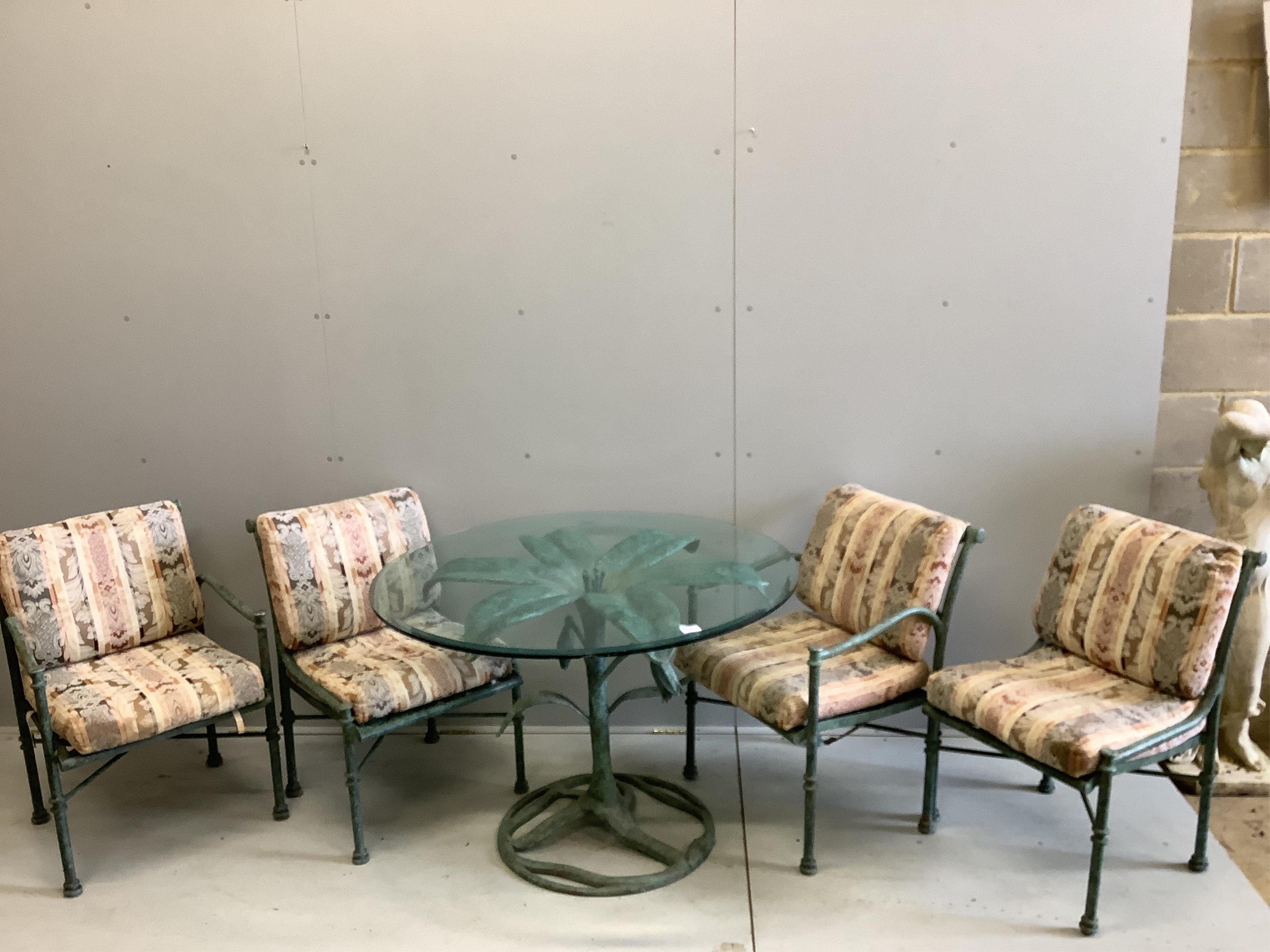 A green patinated iron palm tree design glass topped conservatory table, diameter 106cm, height 74cm and four matching armchairs with cushion seats and backs. Condition - fair to good